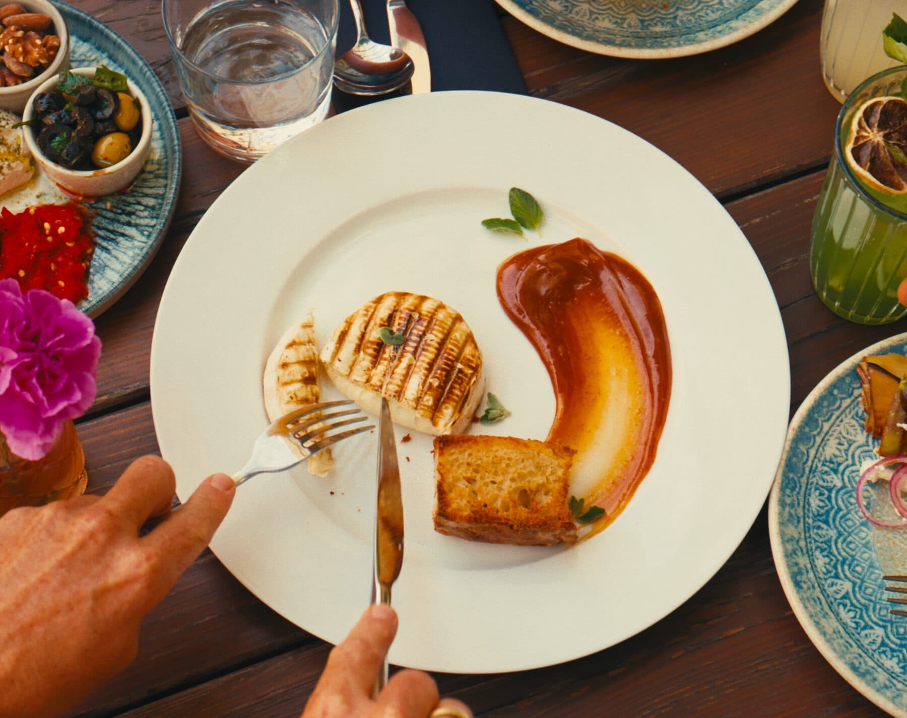 Gegrilltes Hauptgericht mit Sauce auf dem Holztisch